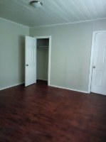 A room with a wooden floor and a white door.
